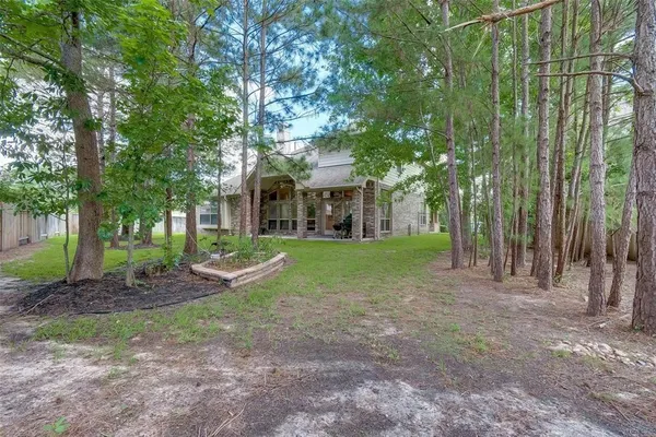 a view of a house with a big yard and large trees