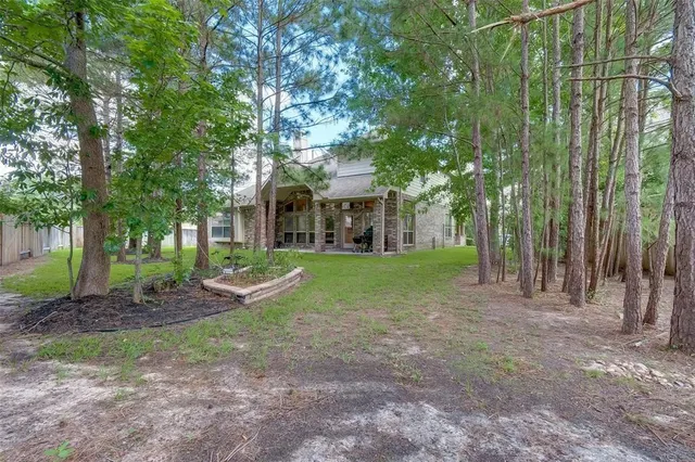 a view of a house with a big yard and large trees