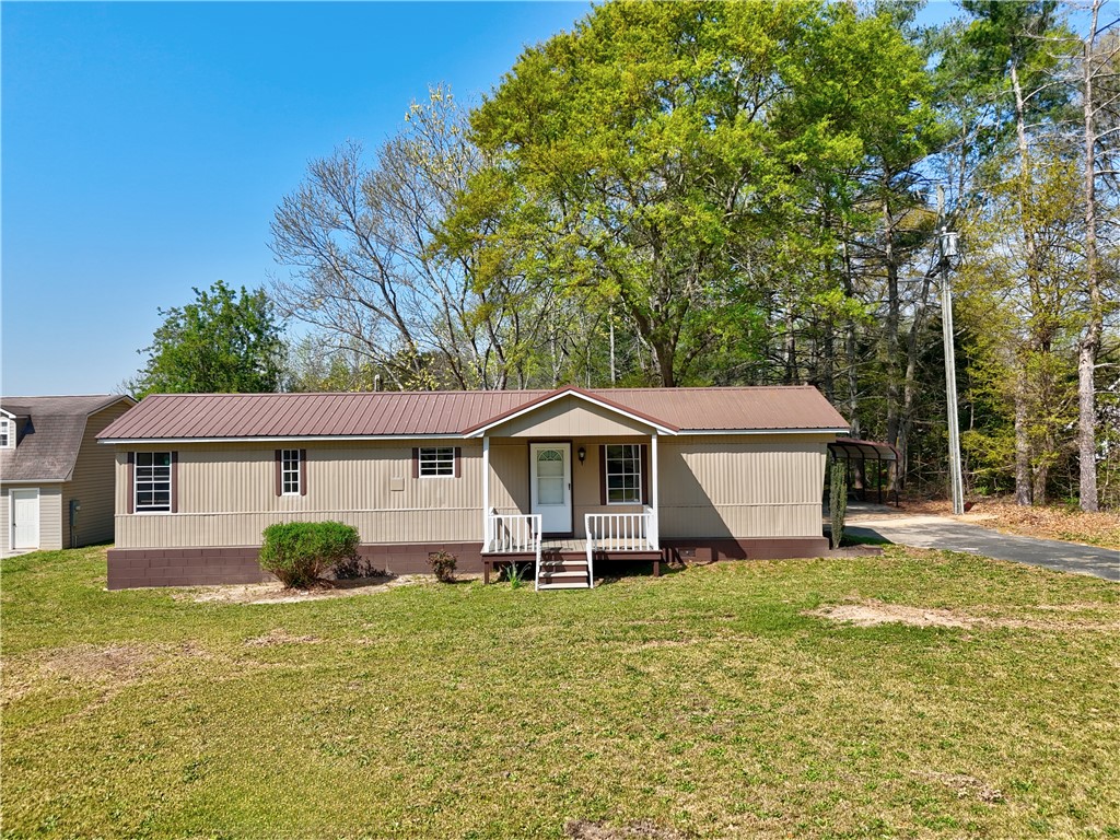 220 Bill Kay Road Belton, SC 29627 - Photo 2 of 30 A charming residence with a welcoming porch awaits, offering a serene escape amidst lush greenery.