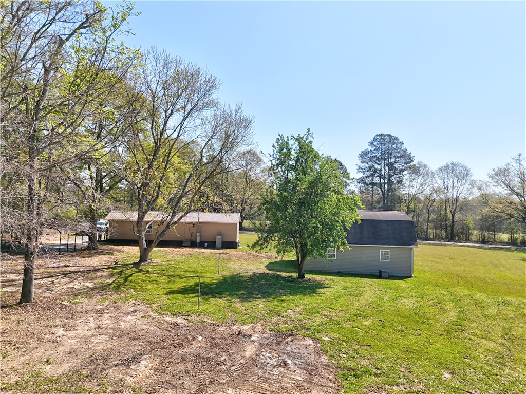 220 Bill Kay Road Belton, SC 29627 - Photo 25 of 30 This verdant expanse includes two structures, offering ample outdoor living space under clear skies.