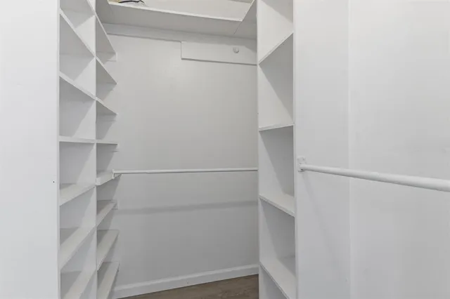 a view of walk in closet with empty racks