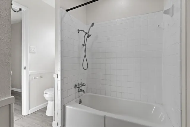 a white bath tub sitting next to a white toilet and a shower