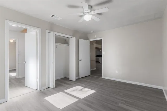 an empty room with closet and windows
