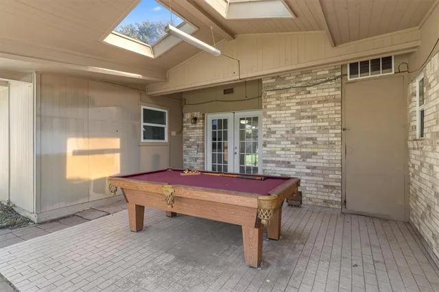 a room with pool table and windows