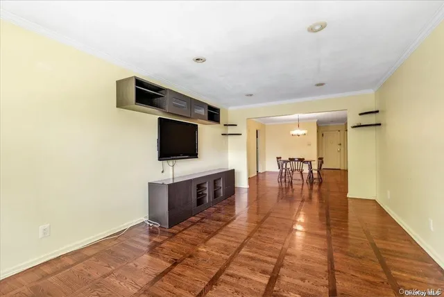 a view of a hallway with wooden floor and a living room