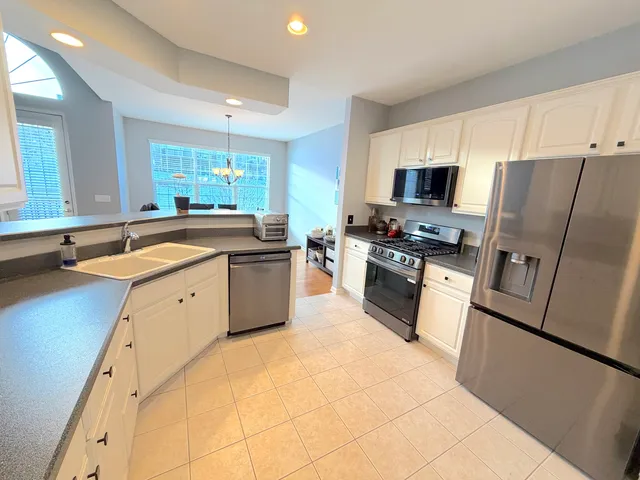a kitchen with a sink a counter top space stainless steel appliances and a window