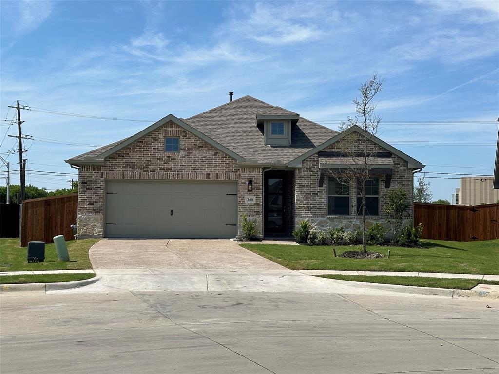 View of front of property featuring brick siding, concrete driveway, a shingled roof, and an attached garage