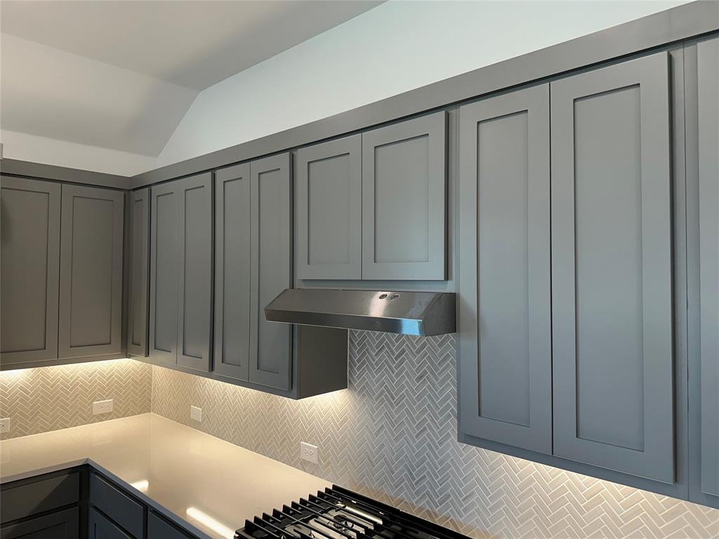 3401 Paintbrush Path Melissa, TX 75454 - Photo 22 of 39 Kitchen featuring gray cabinetry, tasteful backsplash, lofted ceiling, stainless steel gas stovetop, and light stone counters