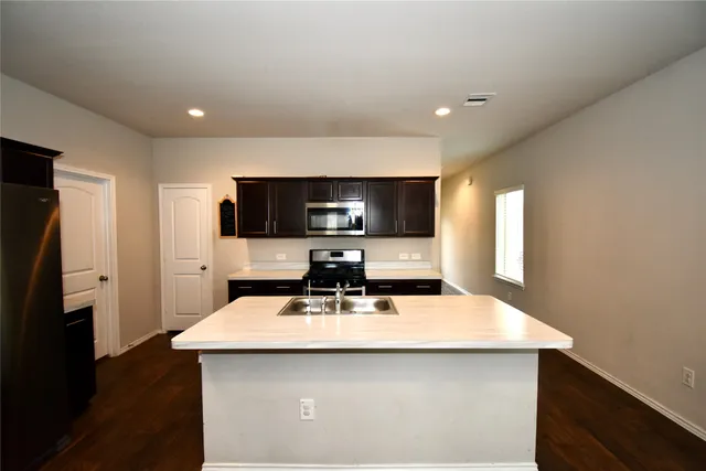 a kitchen with a sink a counter top space and stainless steel appliances