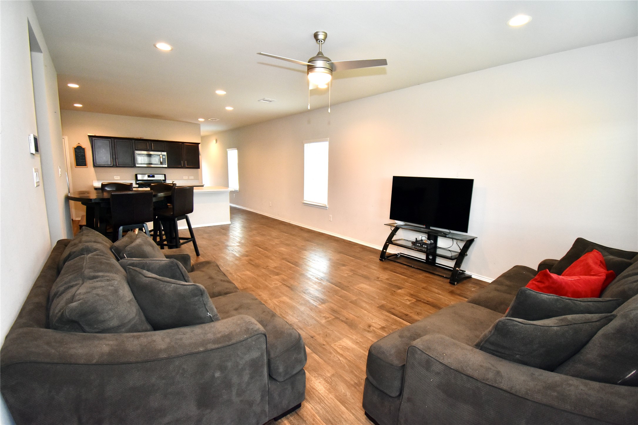22830 Zephyr Vly Trail Spring, TX 77373 - Photo 8 of 17 a living room with furniture and a flat screen tv with kitchen view