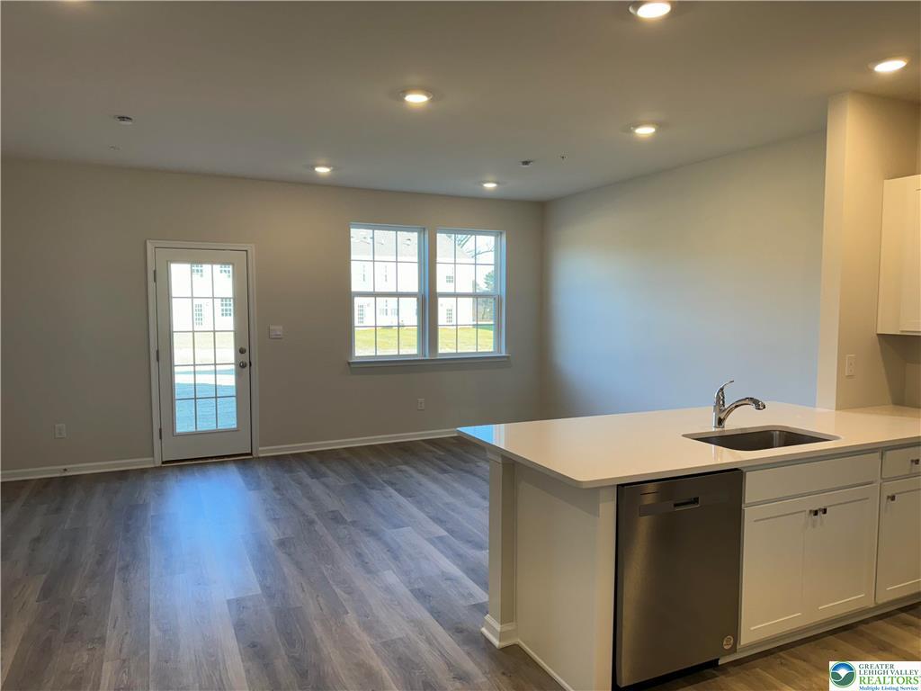1145 Martin Road Breinigsville, PA 18031 - Photo 34 of 38 Modern kitchen island with integrated sink and dishwasher, open to an adjoining living area.