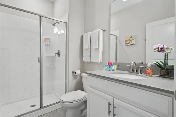 a bathroom with a sink vanity mirror and toilet