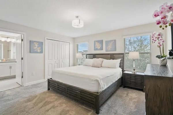 a large bed sitting in a bedroom next to a window and a lamp
