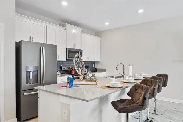 a kitchen with refrigerator and cabinets