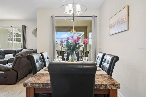 a living room with furniture flowerpot and a chandelier