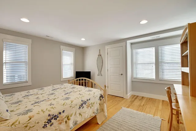 a spacious bedroom with a bed and a dresser next to a window