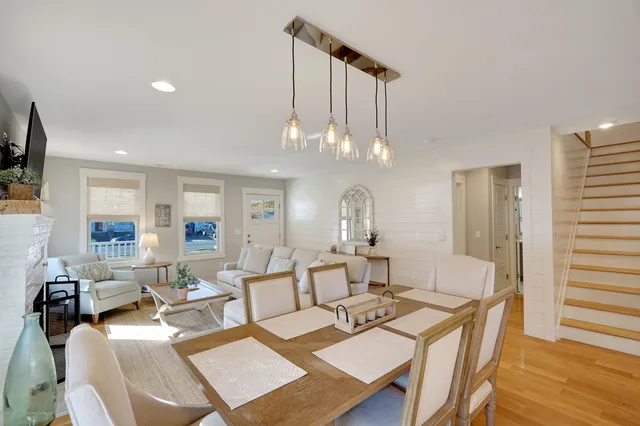 a living room with furniture a chandelier and a dining table
