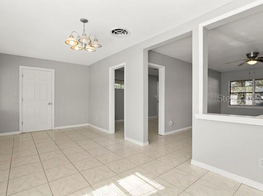 5614 Riviera Drive Orlando, FL 32808 - Photo 6 of 17 an empty room with chandelier and mirror