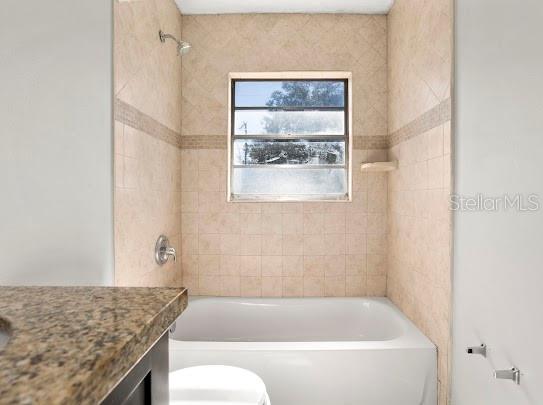 5614 Riviera Drive Orlando, FL 32808 - Photo 10 of 17 a bathroom with a granite countertop bathtub sink and toilet