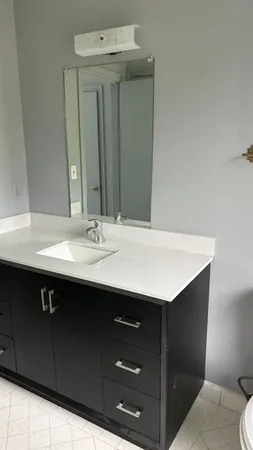 a bathroom with a sink vanity and a mirror