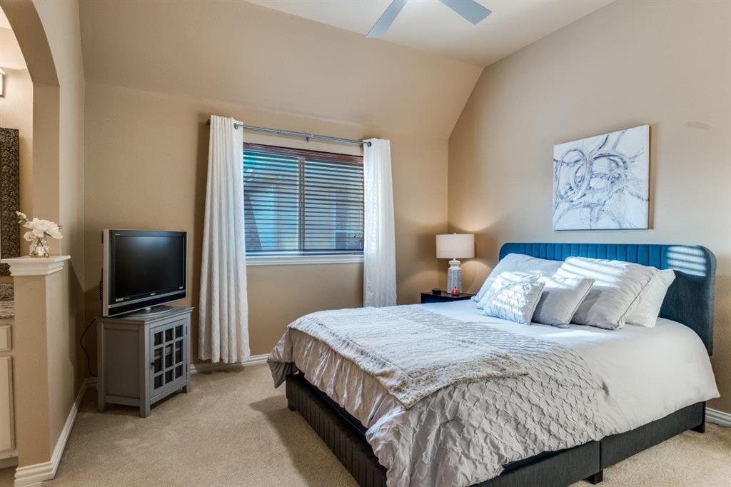 2810 Baker Street Sachse, TX 75048 - Photo 19 of 26 Bedroom featuring light colored carpet, ceiling fan, vaulted ceiling, and arched walkways