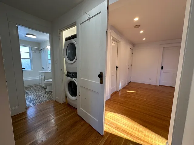 a bedroom with wooden floor and glass door