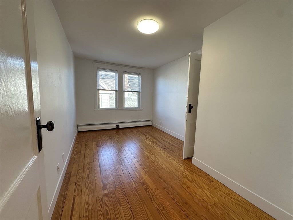 76 Wenham Street, Unit 3 Boston, MA 02130 - Photo 14 of 23 wooden floor in an empty room with a window