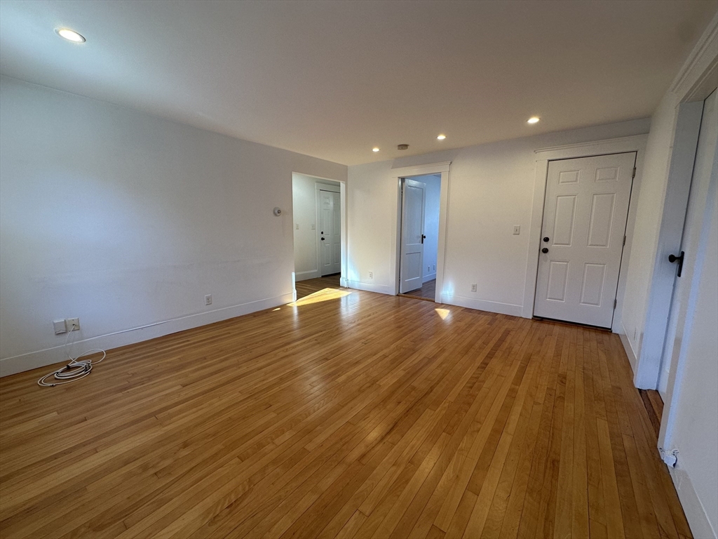 76 Wenham Street, Unit 3 Boston, MA 02130 - Photo 16 of 23 a view of an empty room with wooden floor