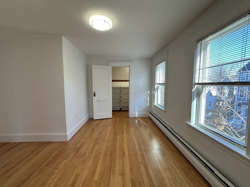 76 Wenham Street, Unit 3 Boston, MA 02130 - Photo 19 of 23 a view of an empty room with wooden floor and a window