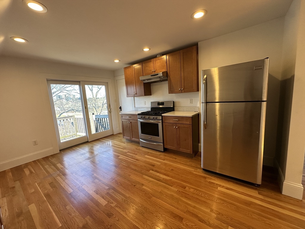 76 Wenham Street, Unit 3 Boston, MA 02130 - Photo 3 of 23 a kitchen with stainless steel appliances a refrigerator and wooden floor