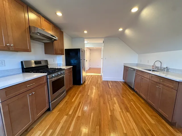 a kitchen with wooden floors and stainless steel appliances