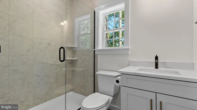 a kitchen with kitchen island granite countertop a sink a counter space appliances and cabinets