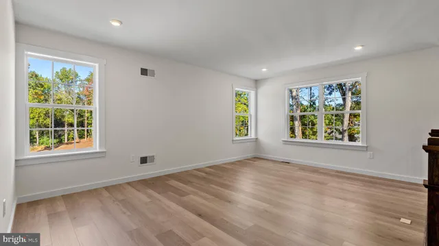 an empty room with wooden floor and entryway