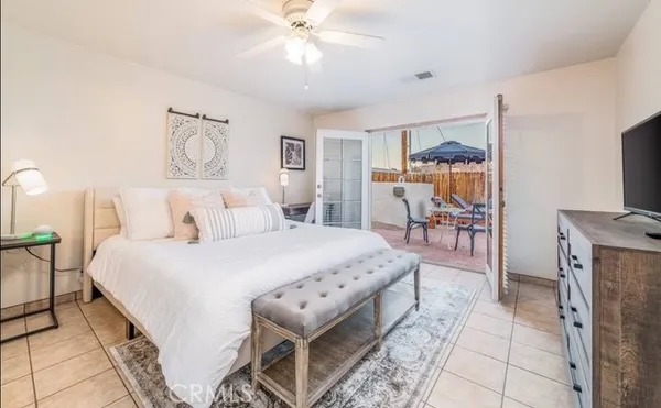 a spacious bedroom with a bed and a flat screen tv