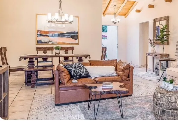 a living room with furniture kitchen view and large windows