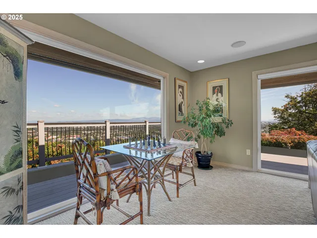 a dining hall with stainless steel appliances kitchen island granite countertop a table chairs and a large window