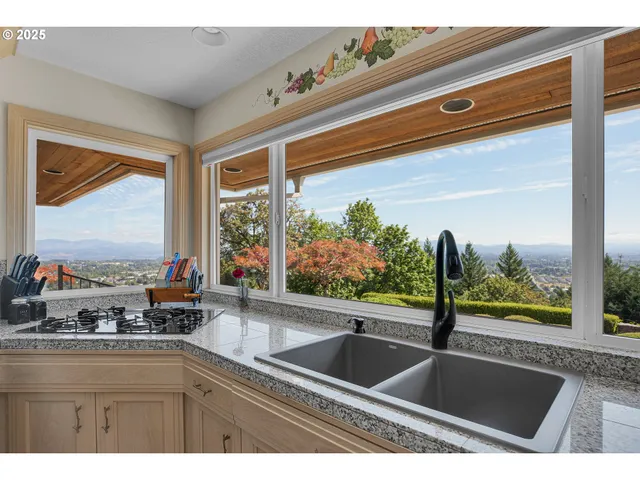 a kitchen with kitchen island granite countertop a sink cabinets and window