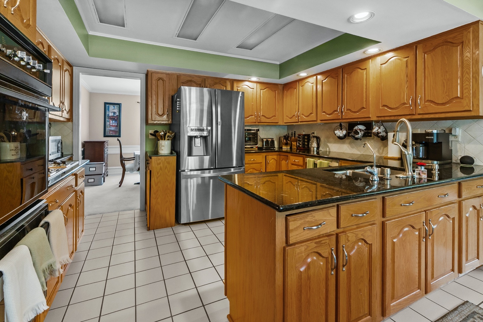 8612 Crystal Springs Road Woodstock, IL 60098 - Photo 9 of 45 a kitchen with granite countertop a refrigerator a stove top oven and cabinets