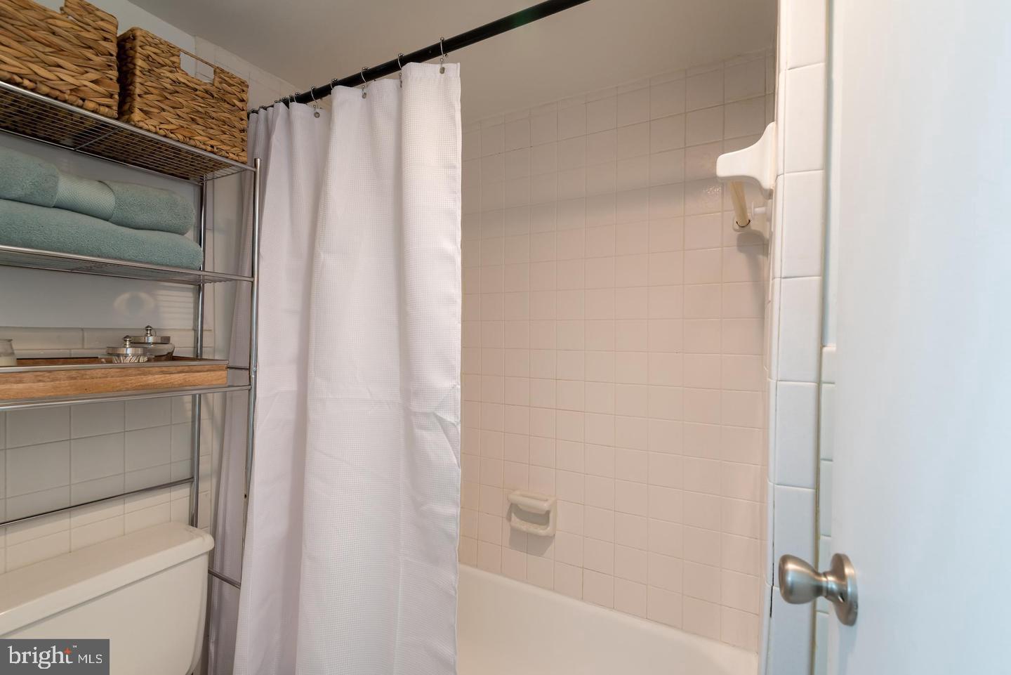2800 Wisconsin Avenue Northwest, Unit 510 Washington, DC 20007 - Photo 18 of 20 a bathroom with a shower curtain and a toilet