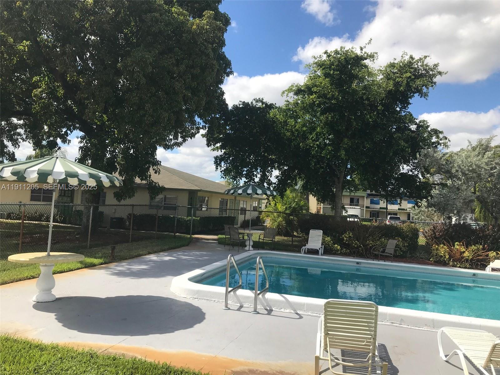 4104 Northwest 88th Avenue, Unit 2 Coral Springs, FL 33065 - Photo 2 of 9 a swimming pool with outdoor seating and yard