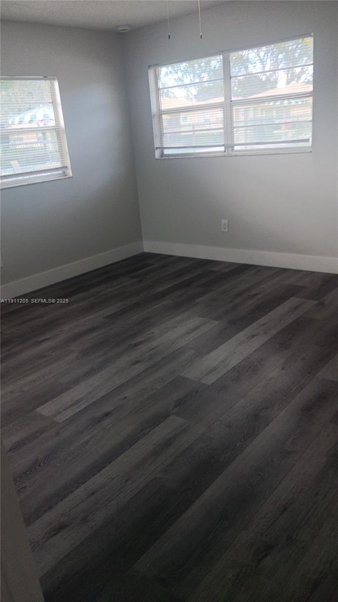 4104 Northwest 88th Avenue, Unit 2 Coral Springs, FL 33065 - Photo 6 of 9 an empty room with wooden floor and windows