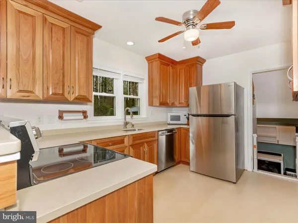 a kitchen with stainless steel appliances granite countertop white cabinets and a sink