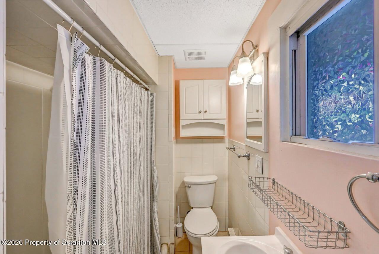 641 East Elm Street Scranton, PA 18505 - Photo 42 of 59 a bathroom with a toilet a sink and a shower curtain