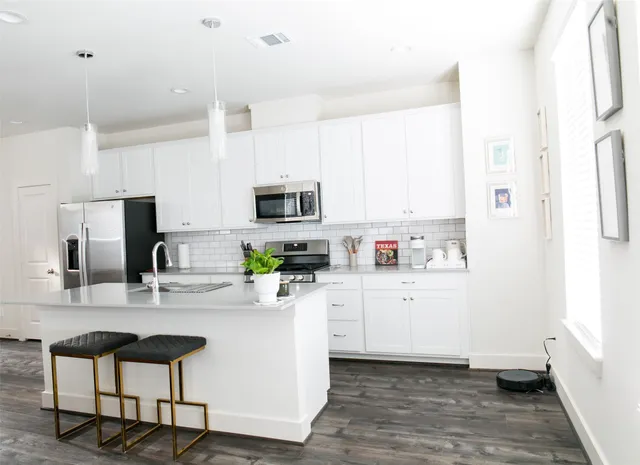 a kitchen with a sink cabinets stainless steel appliances and a window