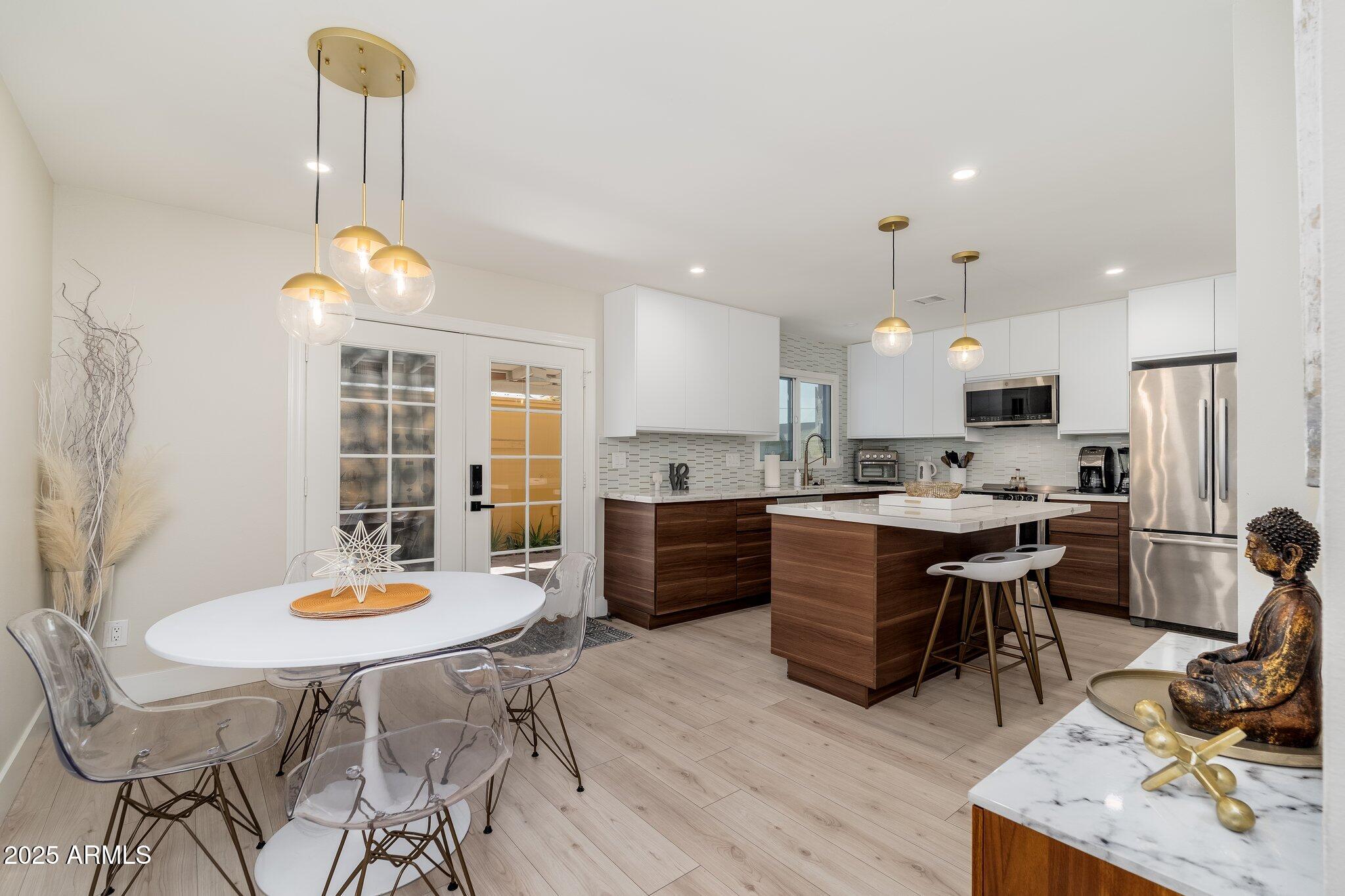 a kitchen with a dining table chairs and refrigerator
