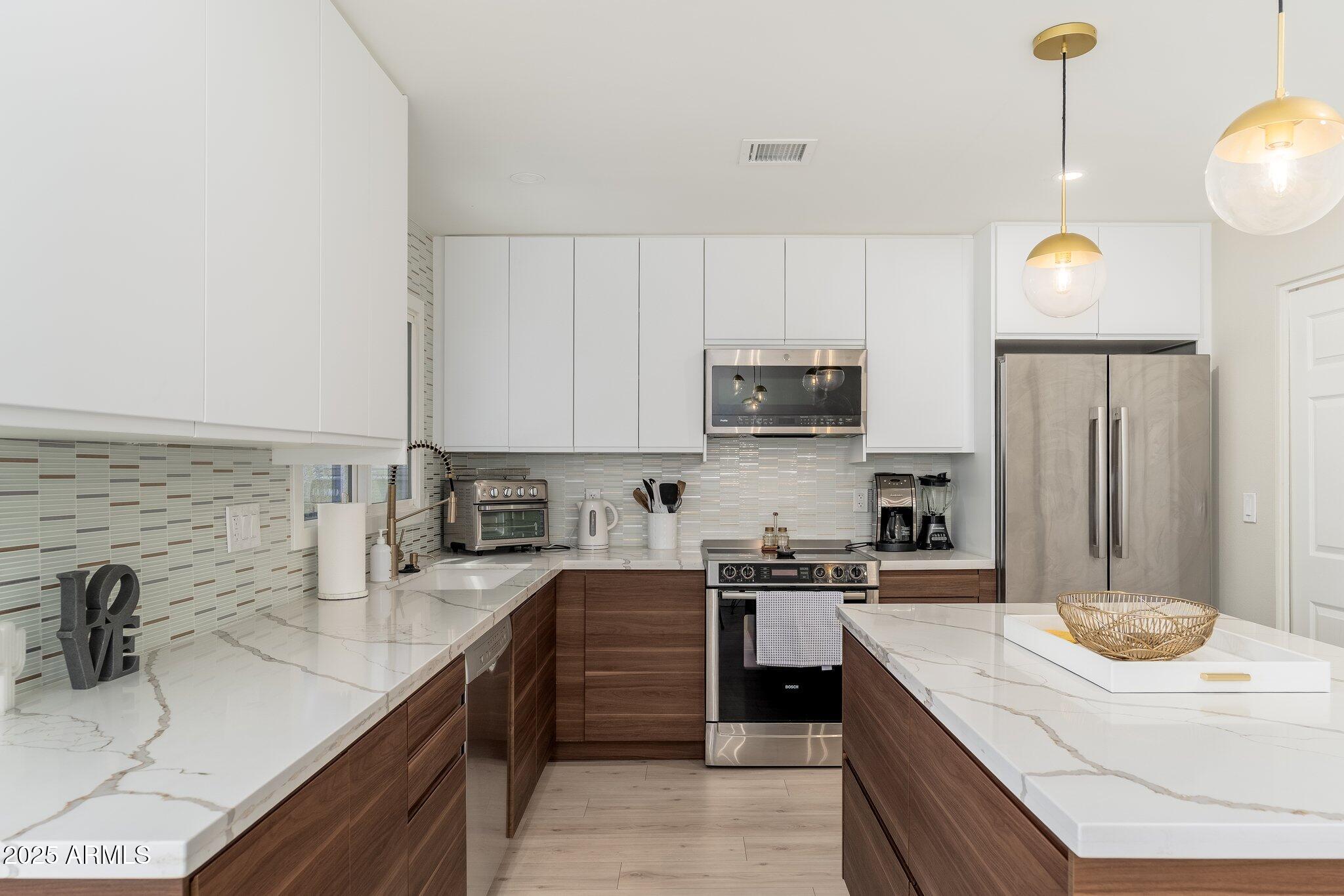 6957 East Osborn Road, Unit A Scottsdale, AZ 85251 - Photo 11 of 29 a kitchen with kitchen island granite countertop a sink a counter space appliances and cabinets
