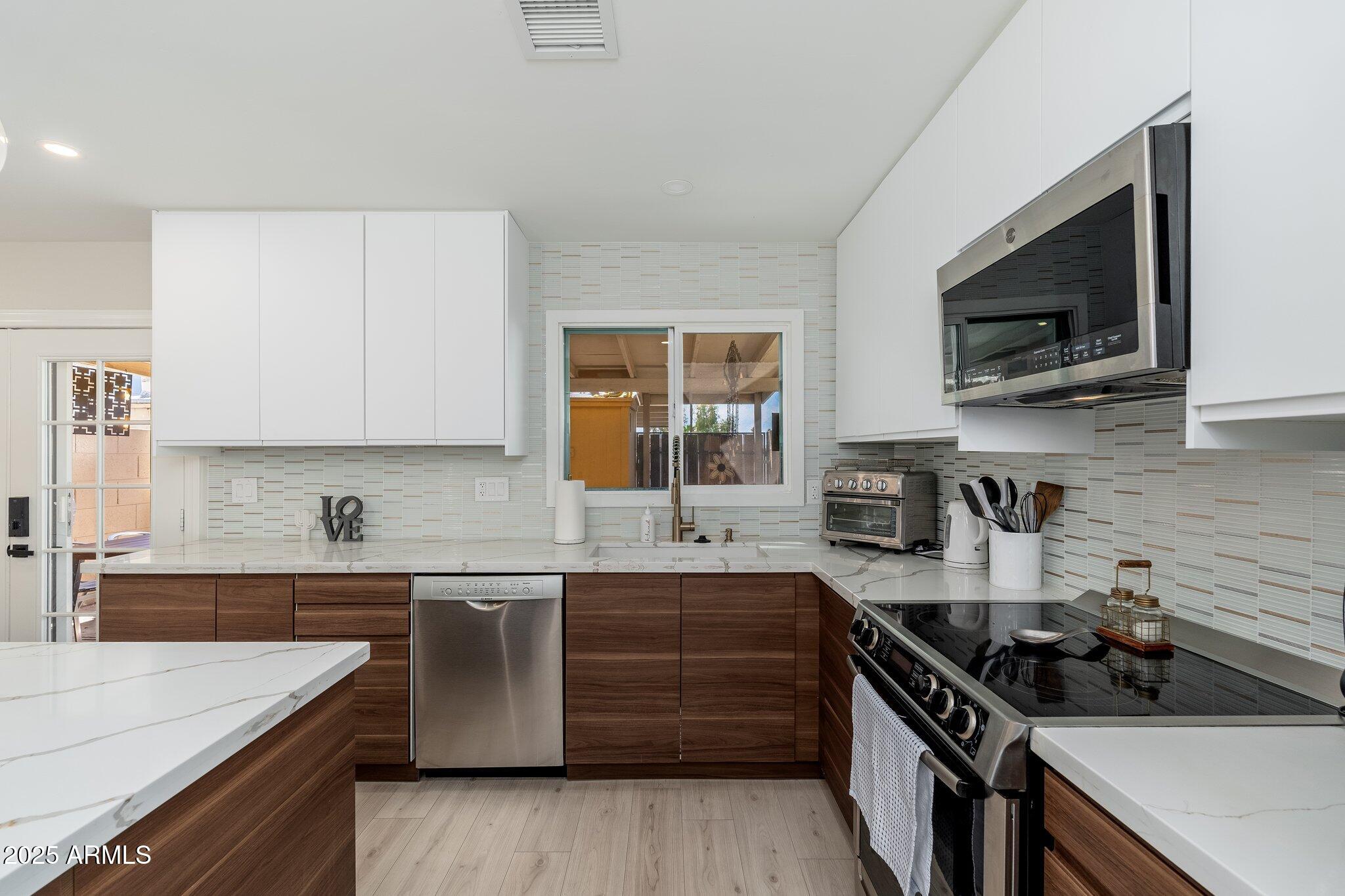 6957 East Osborn Road, Unit A Scottsdale, AZ 85251 - Photo 13 of 29 a kitchen with stainless steel appliances a sink stove and microwave