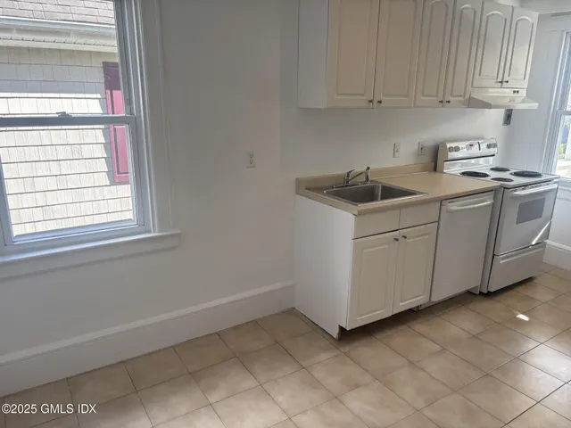 a view of a kitchen with white cabinets