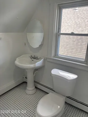a bathroom with a sink a toilet and a window
