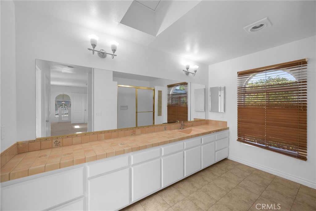 1128 South Parton Street Santa Ana, CA 92707 - Photo 12 of 17 a spacious bathroom with a granite countertop sink a mirror and shower